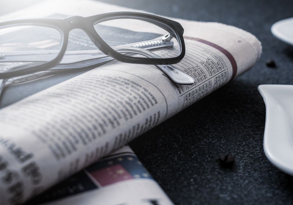 新聞の上に置かれたメガネ